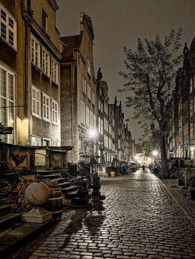 Street amidst buildings in city at night