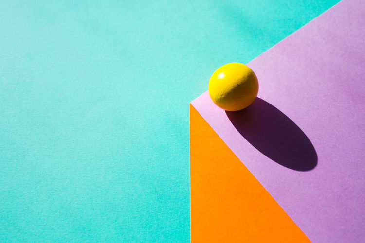 High angle view of yellow ball on colored backgrounds