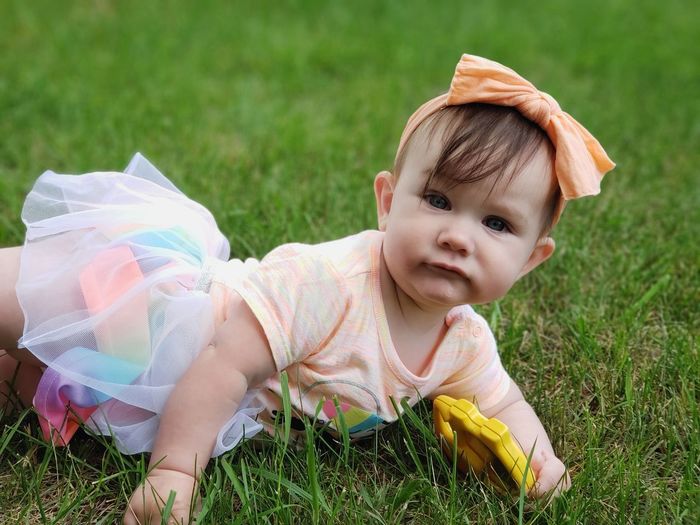 Portrait of baby girl lying on grass