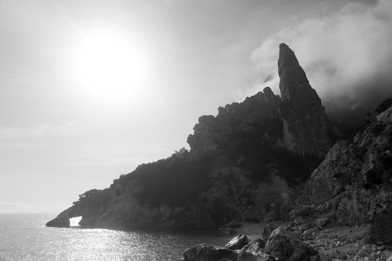 Rock formations by sea against sky