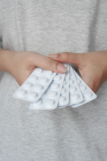 Midsection of woman holding pills