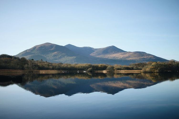 Scenic view of lake and mountains against clear sky