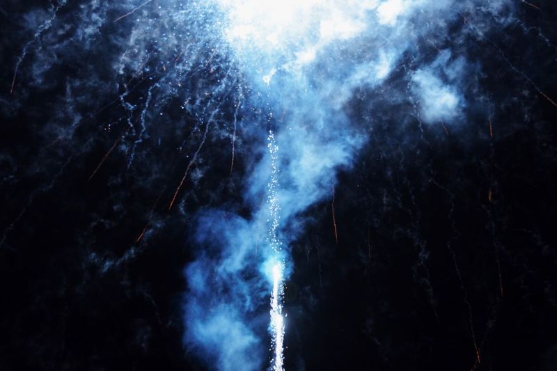 Low angle view of smoke and firework against sky at night