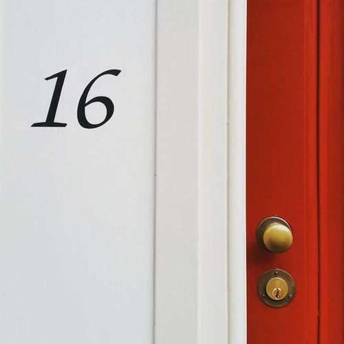 Close-up of number 16 on closed door