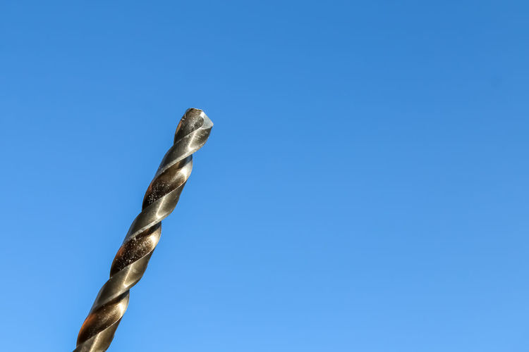 Low angle view of metal against clear blue sky