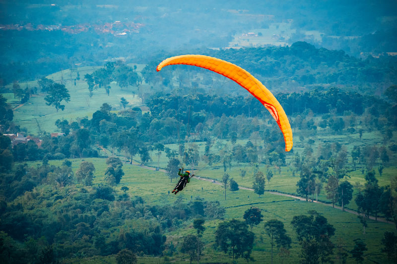 Person paragliding against mountain