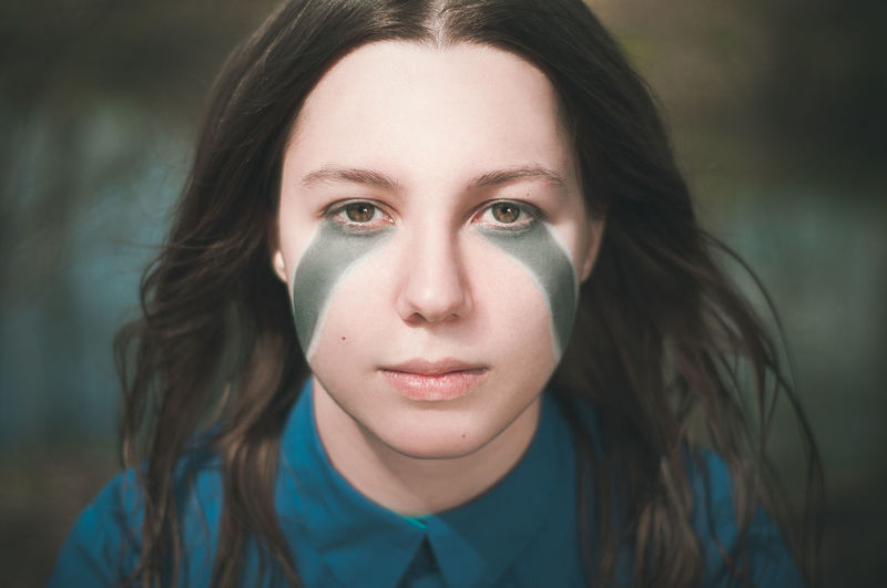 Close-up portrait of young woman with face paint