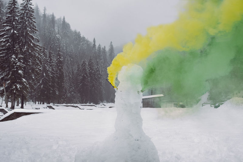 Distress flare emitting from snowman during winter