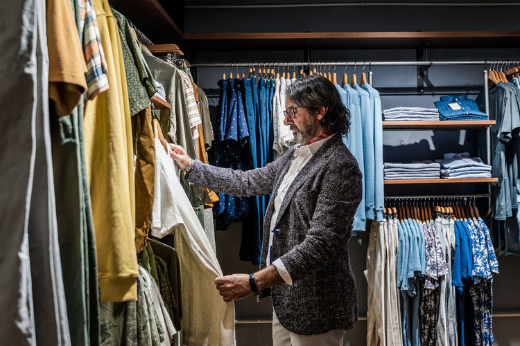 Side view of man choosing clothes in a clothing store person