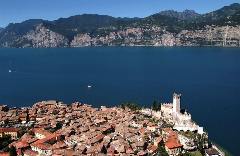 High angle view of townscape by lake garda against sky