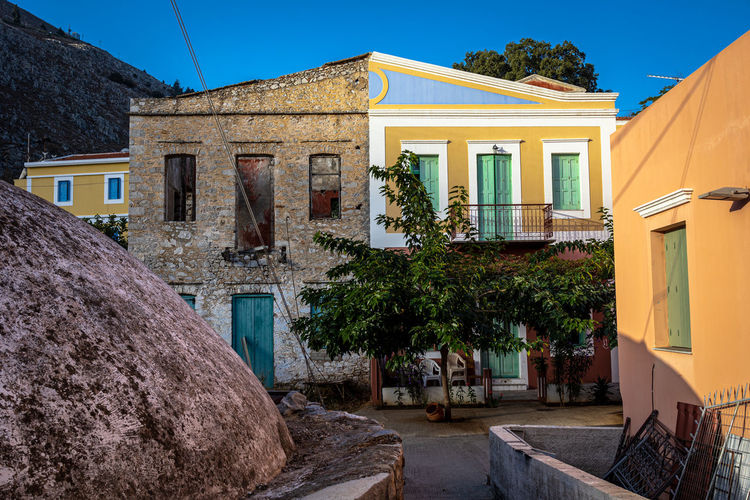 One building, two facades, variety of colors in the narrow street of the enchanting symi