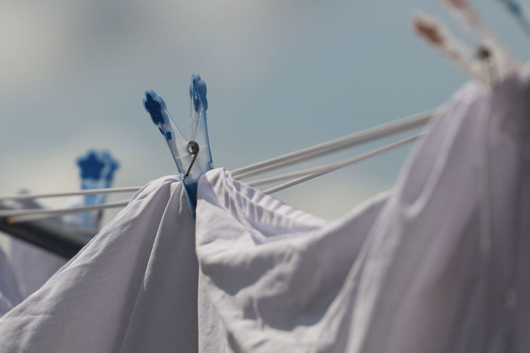 Low angle view of clothes hanging on rope against sky
