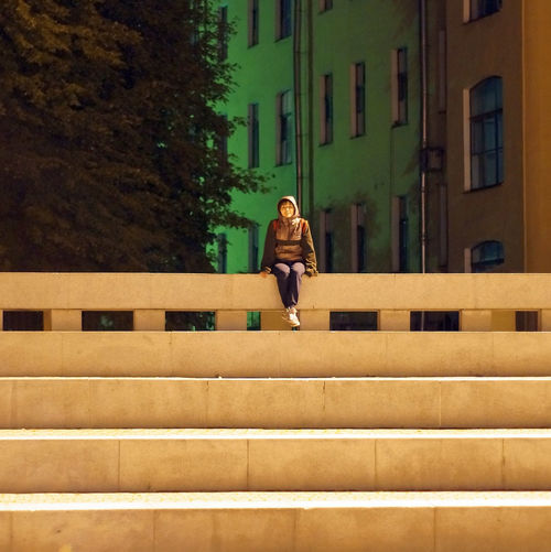 View of young woman sitting on concrete staircase