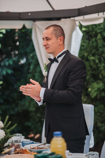 Man wearing suit applauding by dining table