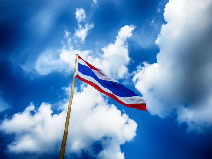Low angle view of thai flag on bamboo against sky
