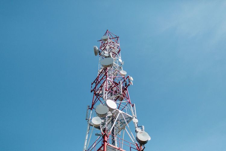 Low angle view of communications tower against blue sky