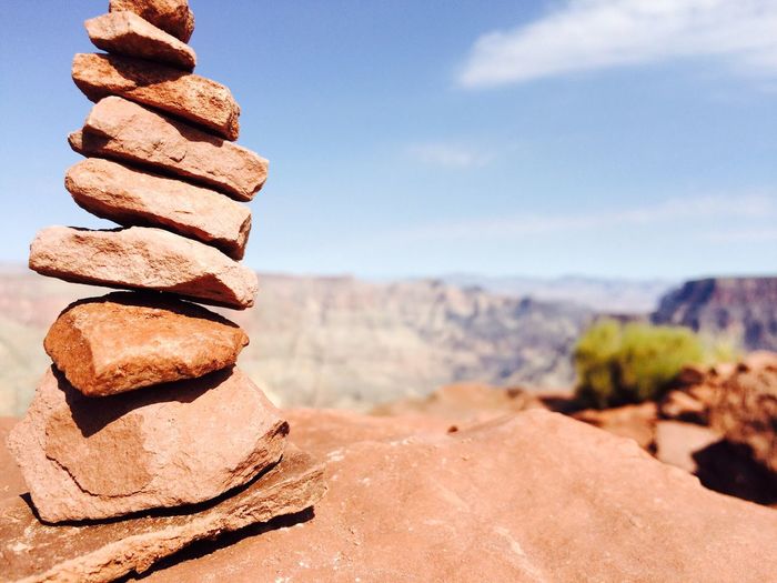 Stack of rocks on desert against sky