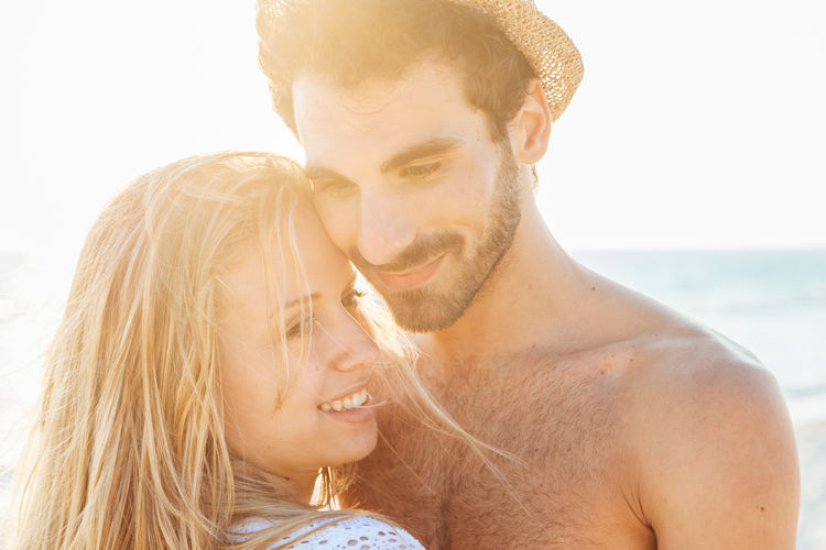 Portrait of young couple kissing at beach