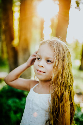 Bright vertical portrait of young girl with hand in her hair