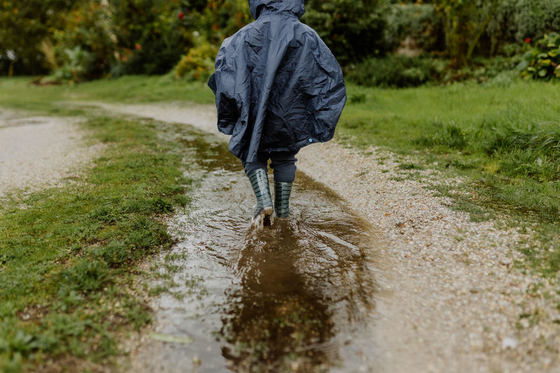Rear view of man walking on dirt road