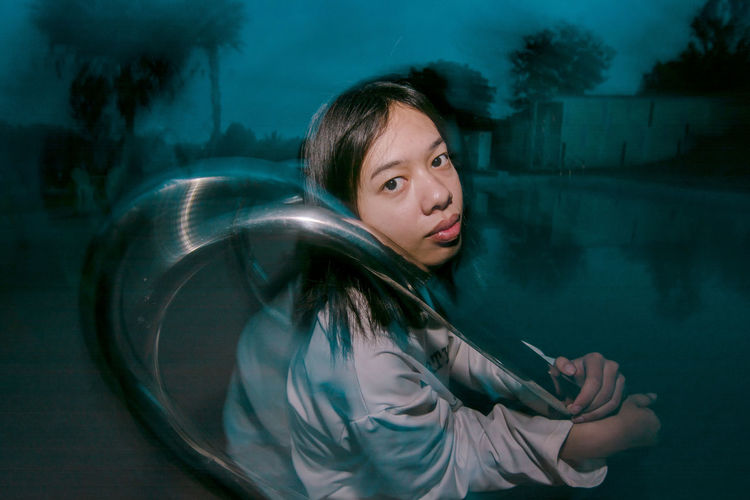 Portrait of young woman in water at night