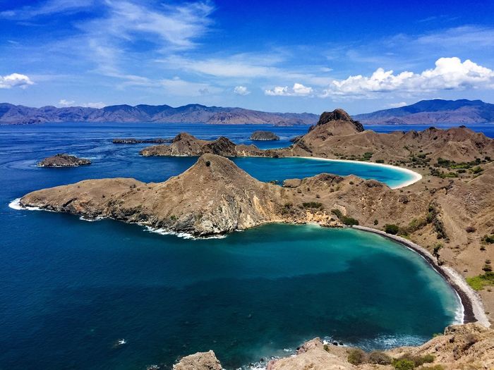 Scenic view of rocky mountains and sea against sky at padar island