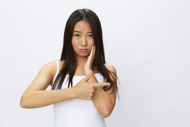 Portrait of young woman against white background
