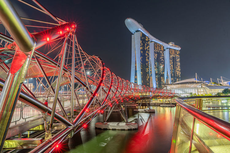 Illuminated bridge over river at night
