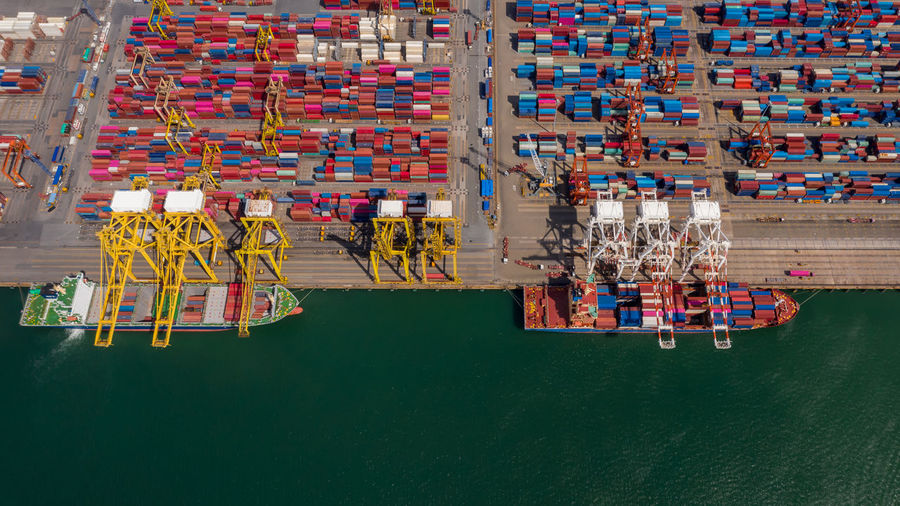 Container ship loading and unloading in sea port, aerial view of business logistic import 