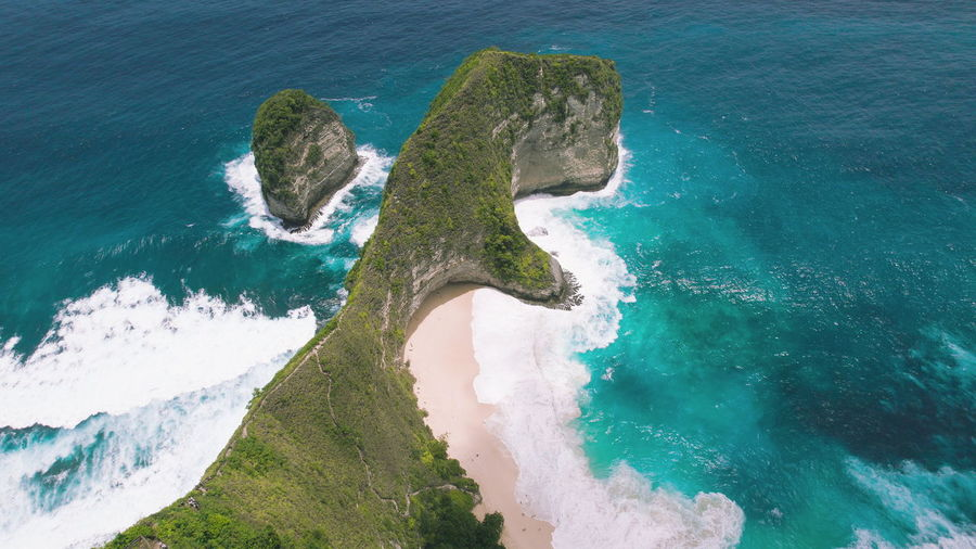 Tropical kelingking sandy beach with rocky cliff and turquoise ocean. nusa penida island bali.