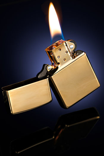 Close-up of lit candle against black background