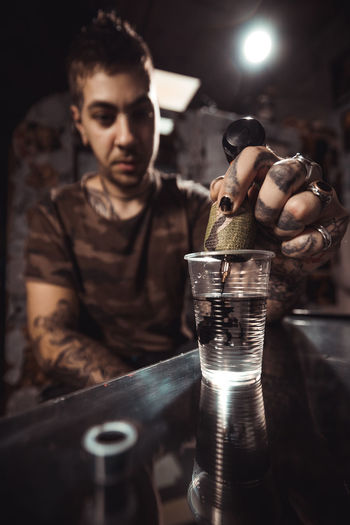 Close-up of man holding drink in glass on table