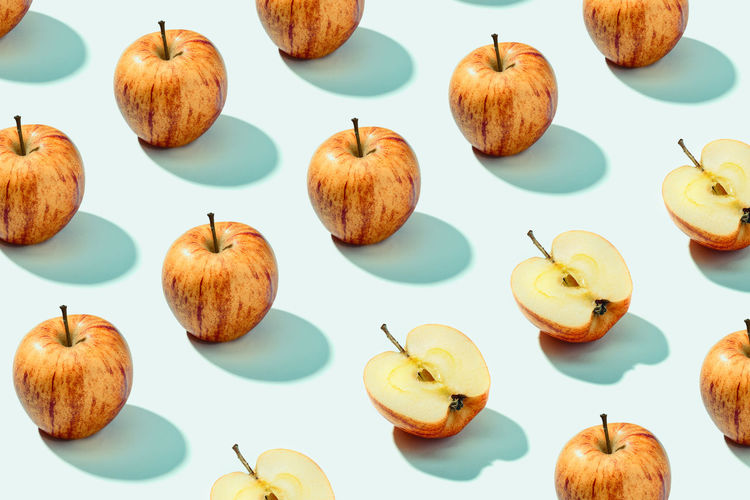 Pattern background of red apples on cyan background. vibrant colorful pattern