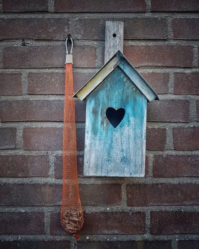 Low angle view of birdhouse on wall of building