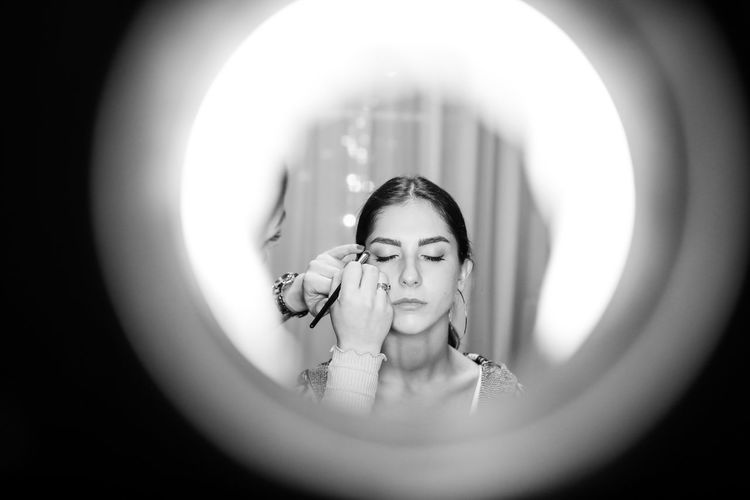 Midsection of artist applying make-up on teenage girl 