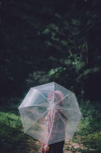 Woman holding umbrella standing on rainy day