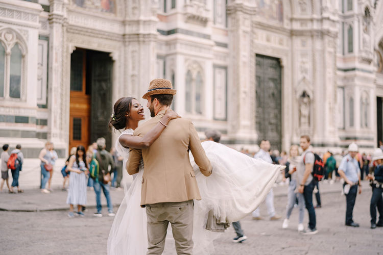 Couple embracing in front of building on street