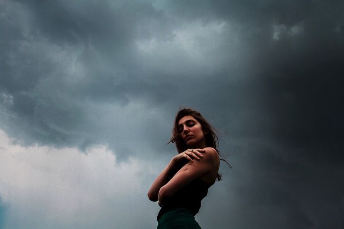 Young woman against stormy sky