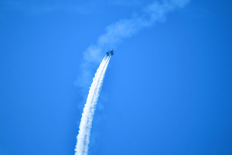 Low angle view of airshow against sky