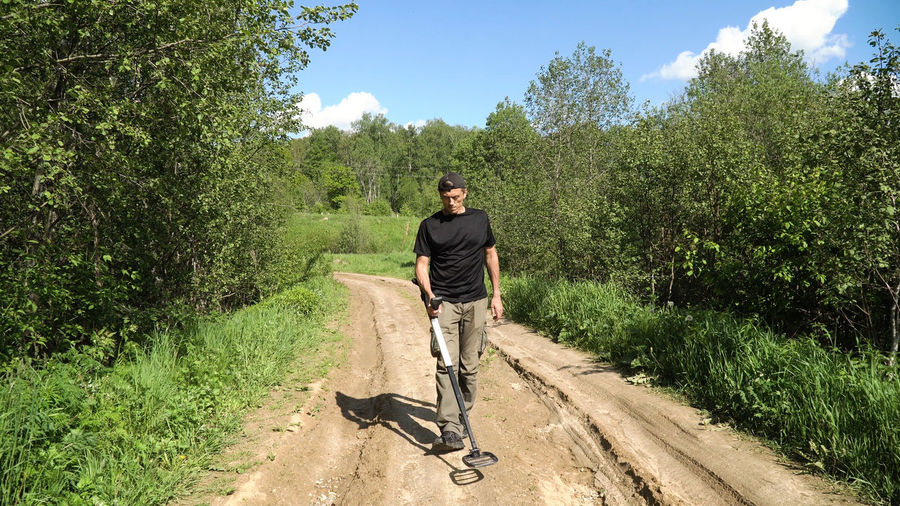 Man with a metal detector are looking for treasure.