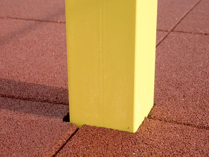 Yellow iron bar on workout playground. the beam holds horizontal acrobatic pole.