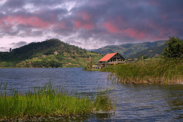 Scenic view of lake by buildings against sky