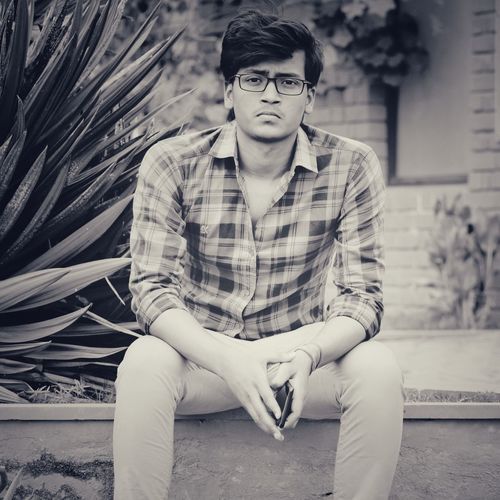 Portrait of young man sitting outdoors