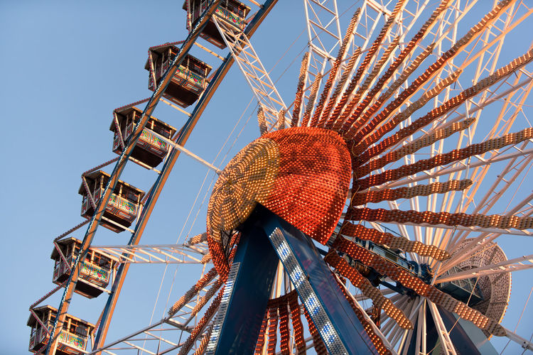 Low angle view of illuminated ferris wheel against clear sky