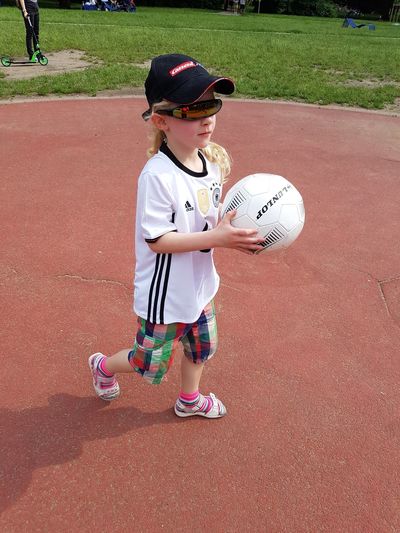 Cute girl holding soccer ball in park