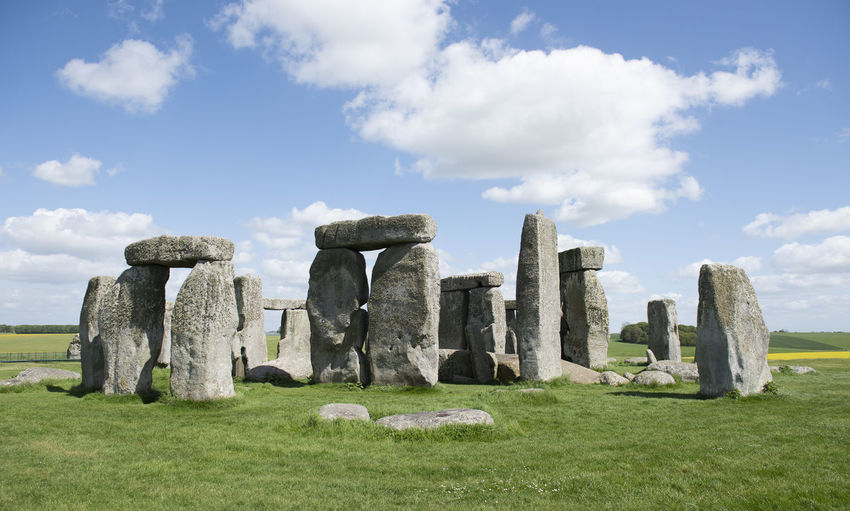 Stonehenge structure in field against cloudy sky