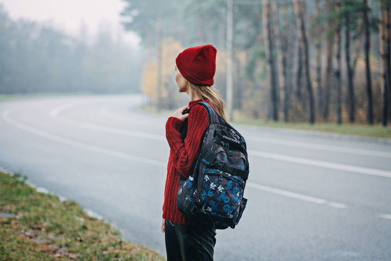 Sustainable tourism, responsible travel. young woman traveler with backpack in pine forest