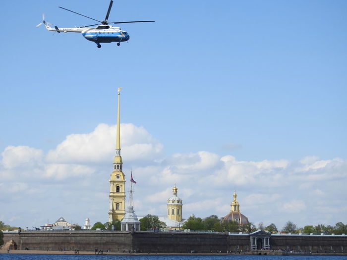 Low angle view of helicopter flying in building against sky