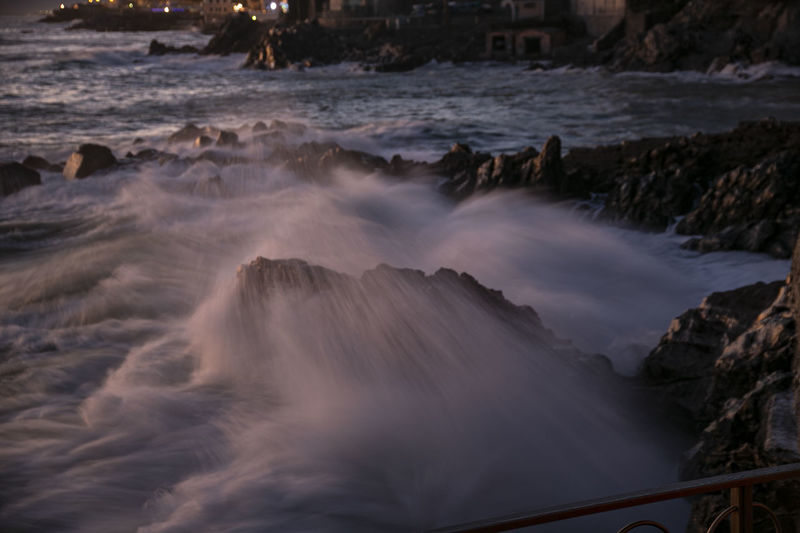 Scenic view of sea waves rushing towards rocks
