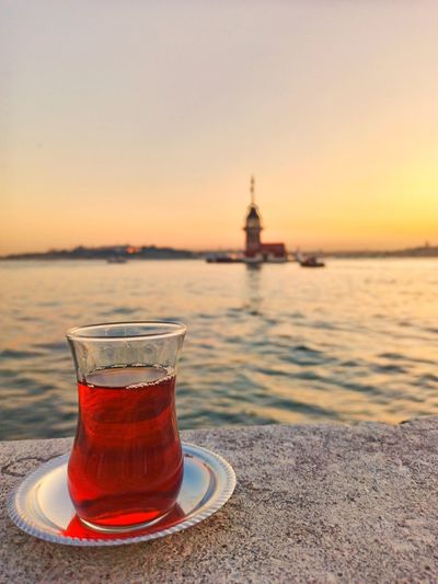 View of tea in sea against sky during sunset